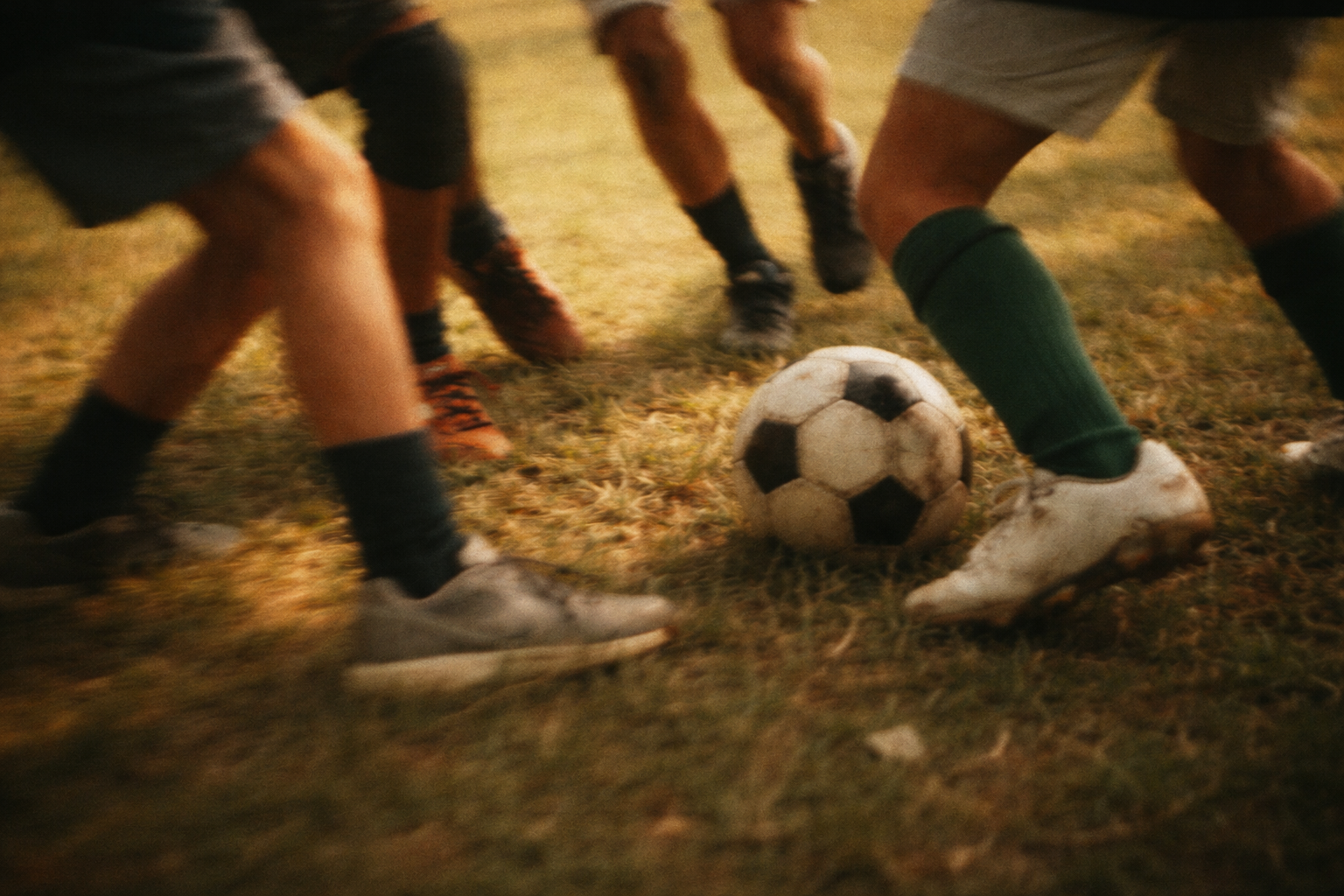 Soccer players in action on a grass field with a vintage filter.