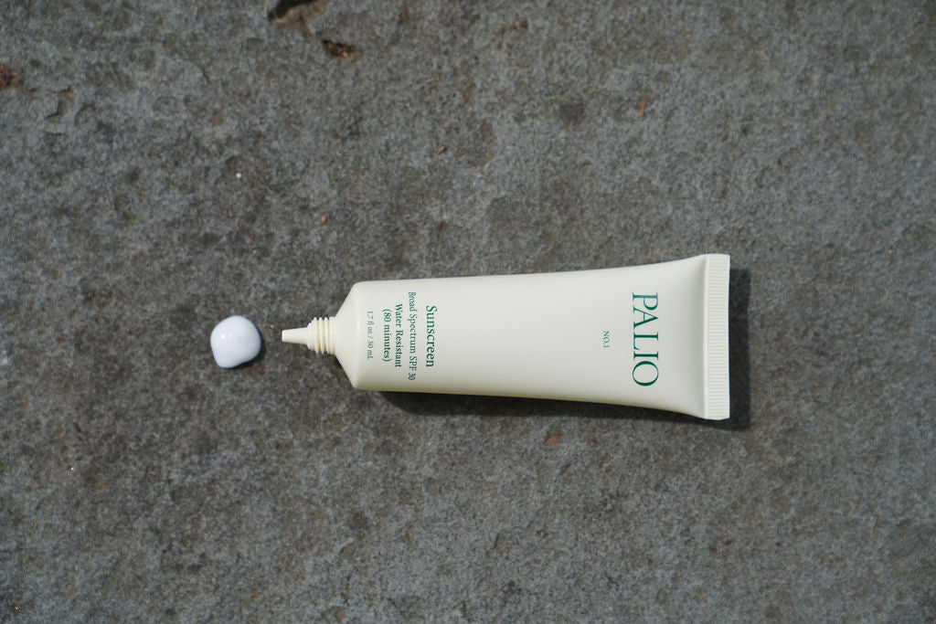 Tube of Palio sunscreen with a small amount of cream on a concrete surface
