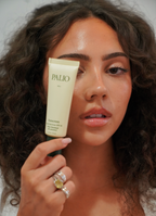 Woman holding a tube of Palio sunscreen in front of her face
